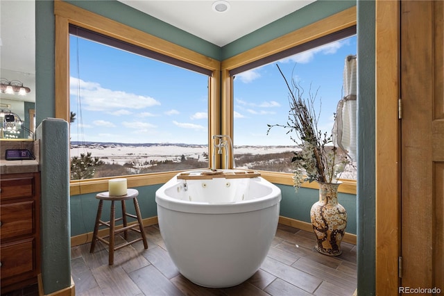 full bathroom featuring baseboards, a freestanding tub, and wood tiled floor