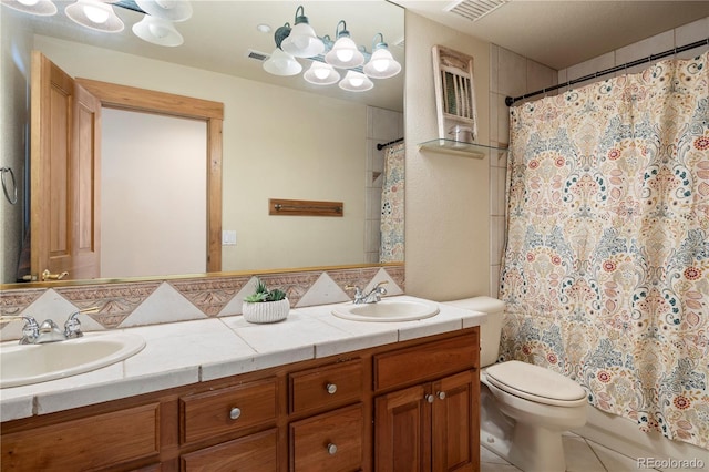 bathroom with toilet, double vanity, a sink, and visible vents