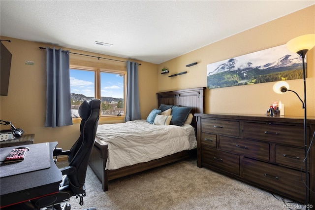 bedroom with light carpet, visible vents, and a textured ceiling