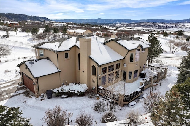 snowy aerial view featuring a mountain view