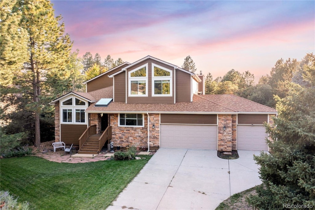 view of front of home with a garage and a lawn