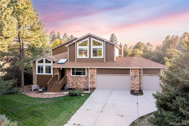 view of front of home with a garage and a lawn