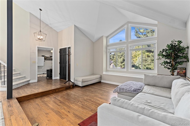 living room featuring hardwood / wood-style flooring, high vaulted ceiling, and a notable chandelier