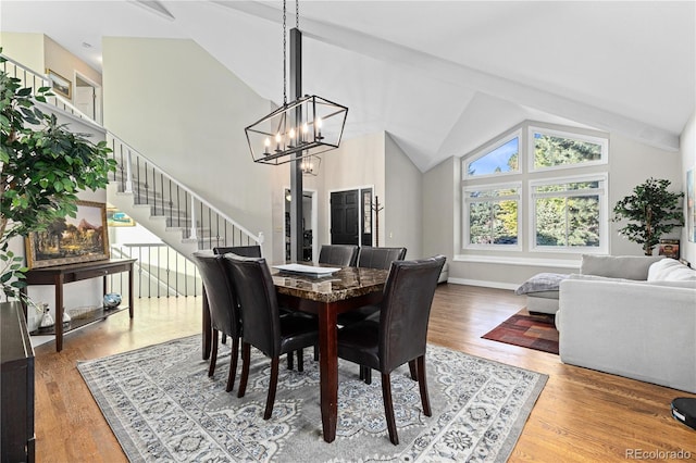 dining room with an inviting chandelier, high vaulted ceiling, and hardwood / wood-style floors