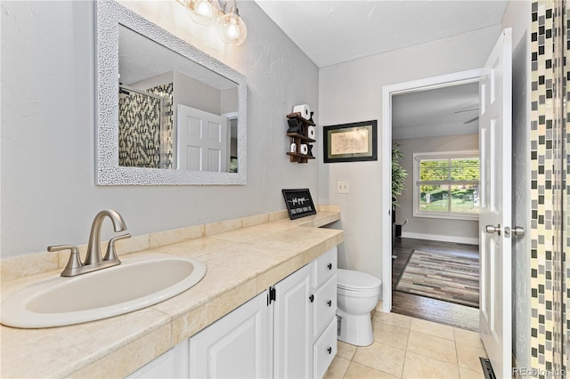 bathroom featuring tile patterned flooring, vanity, curtained shower, and toilet