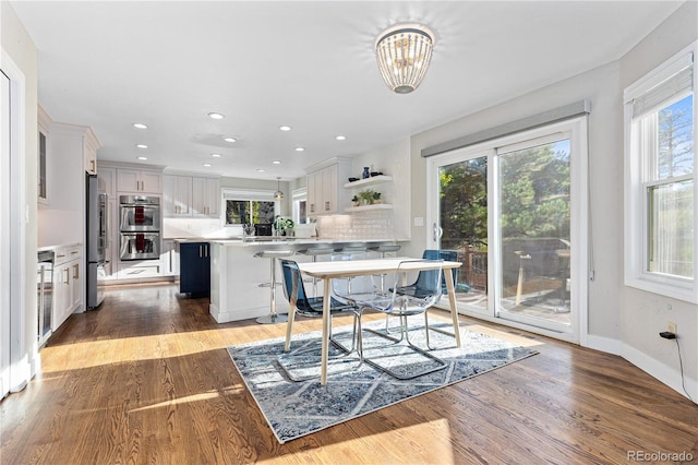 dining area with beverage cooler and light wood-type flooring