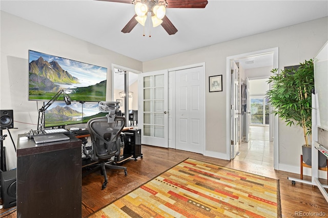 home office featuring wood-type flooring and ceiling fan