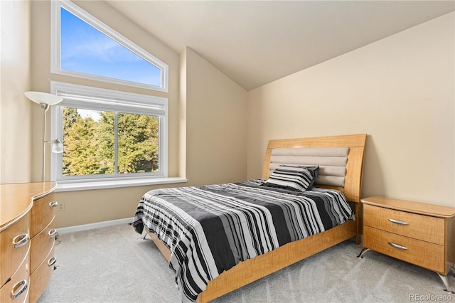 bedroom featuring lofted ceiling and light carpet