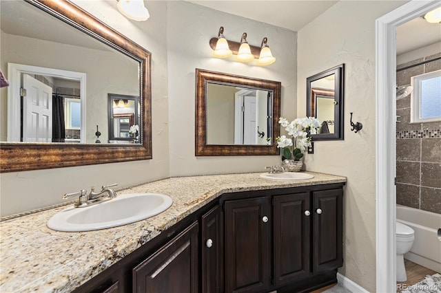 full bathroom with vanity, tiled shower / bath combo, and toilet