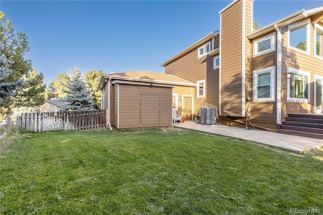 rear view of property featuring a storage shed, a lawn, a patio area, and central air condition unit