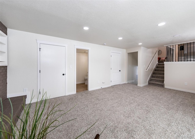 basement featuring a textured ceiling and carpet flooring