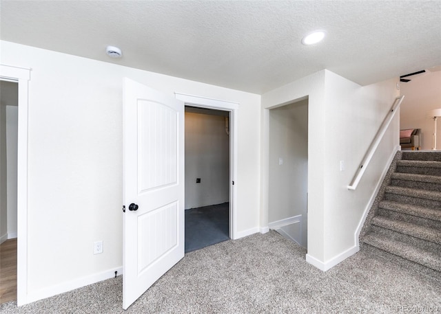 interior space with carpet floors and a textured ceiling