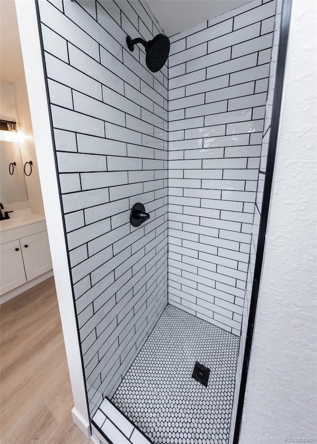 bathroom featuring a tile shower and vanity