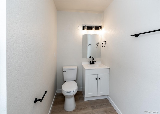 bathroom with vanity, toilet, and wood-type flooring