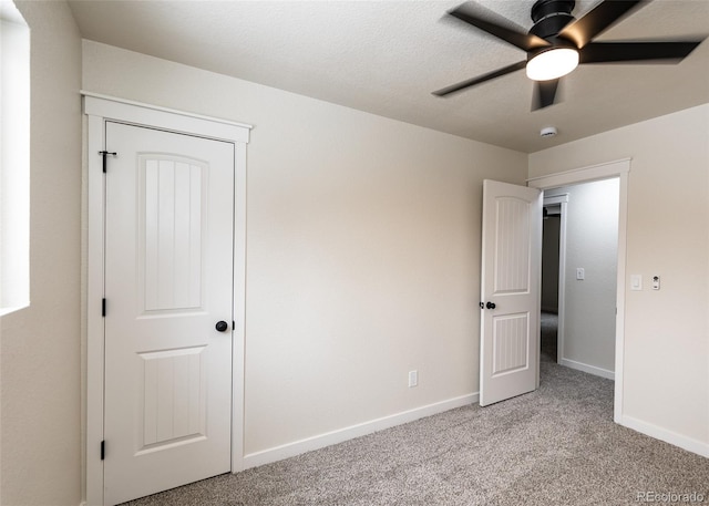 unfurnished bedroom featuring light colored carpet and ceiling fan