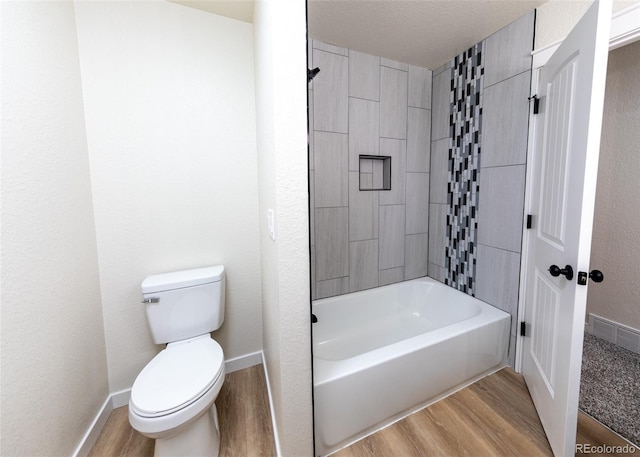 bathroom featuring hardwood / wood-style flooring, toilet, and bathtub / shower combination