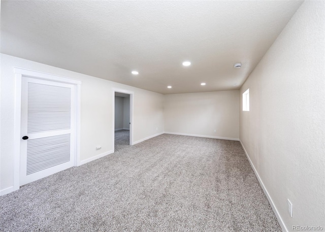 carpeted empty room featuring a textured ceiling