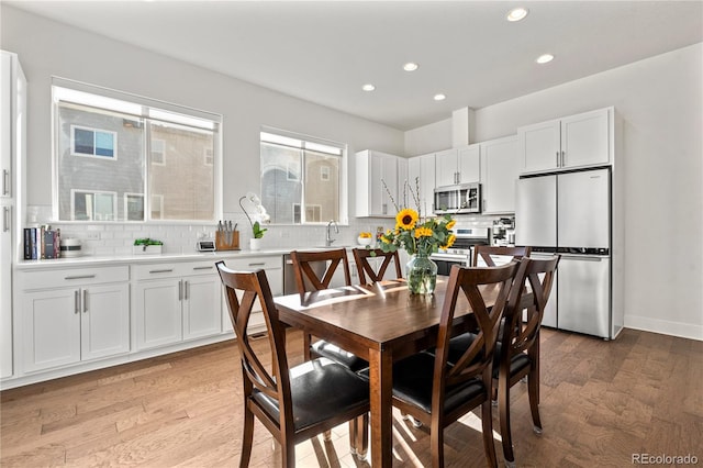 dining space featuring recessed lighting, baseboards, and light wood finished floors