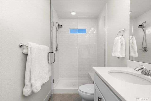 full bathroom featuring toilet, a shower stall, vanity, and tile patterned floors