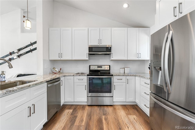 6604 S Dahlia Cir, Centennial, CO 80121 - kitchen featuring stainless steel appliances, lofted ceiling, white cabinetry, decorative backsplash, and recessed lighting