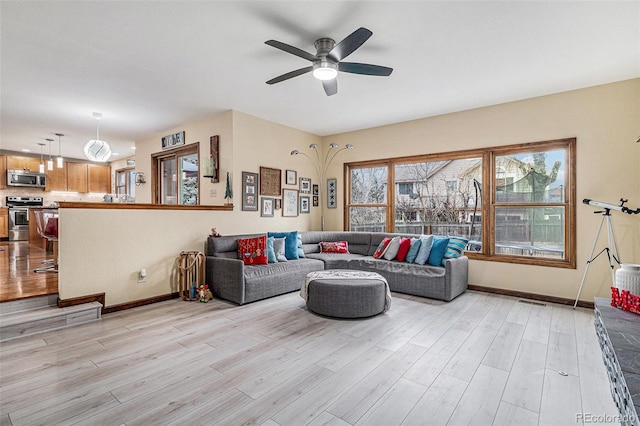 living room with ceiling fan and light wood-type flooring