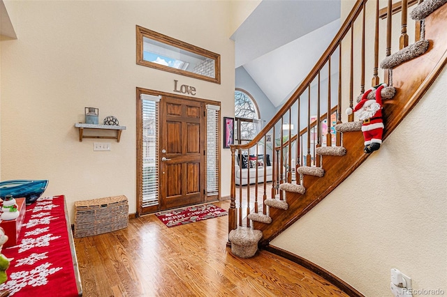 entryway featuring hardwood / wood-style floors and high vaulted ceiling