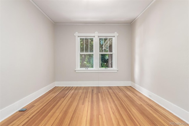 unfurnished room featuring light wood-type flooring and crown molding