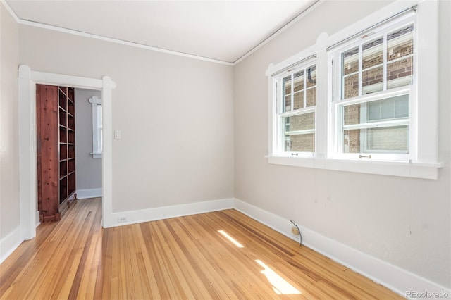 empty room with light wood-type flooring and crown molding