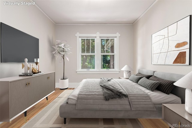 bedroom featuring light wood-type flooring and crown molding