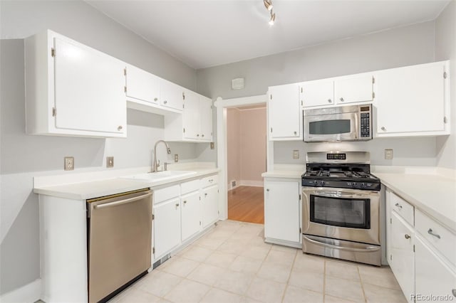 kitchen with white cabinetry, stainless steel appliances, sink, and light hardwood / wood-style floors