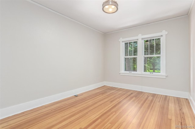 empty room with light wood-type flooring and ornamental molding