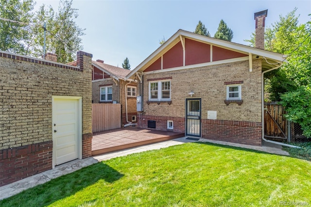 rear view of property featuring a lawn