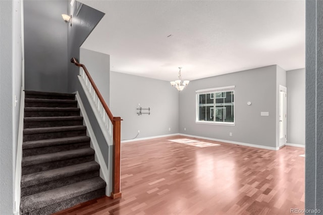 6190 S Oswego St, Englewood, CO 80111 - unfurnished living room with wood finished floors, a chandelier, and stairs