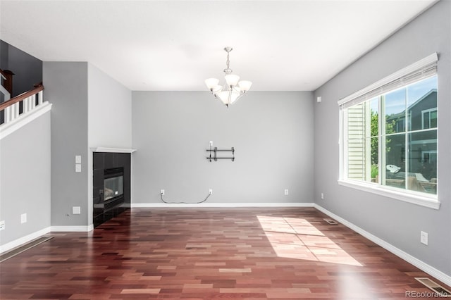 6190 S Oswego St, Englewood, CO 80111 - unfurnished living room featuring wood finished floors, a chandelier, and a fireplace