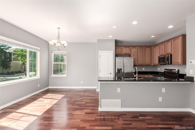 6190 S Oswego St, Englewood, CO 80111 - kitchen featuring stainless steel appliances, dark countertops, dark wood-style floors, a chandelier, and a peninsula