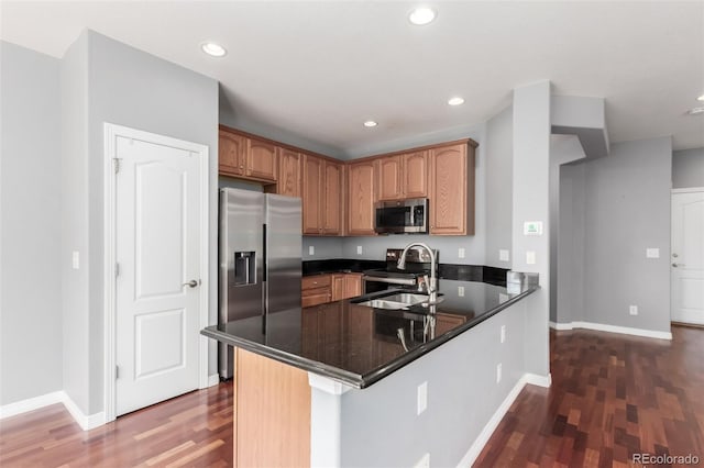 6190 S Oswego St, Englewood, CO 80111 - kitchen featuring stainless steel appliances, dark wood-type flooring, a peninsula, dark countertops, and recessed lighting