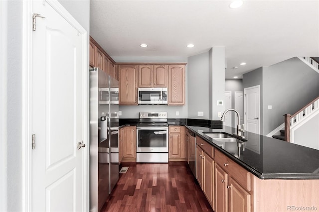 6190 S Oswego St, Englewood, CO 80111 - kitchen with appliances with stainless steel finishes, a peninsula, dark wood-type flooring, recessed lighting, and dark stone countertops
