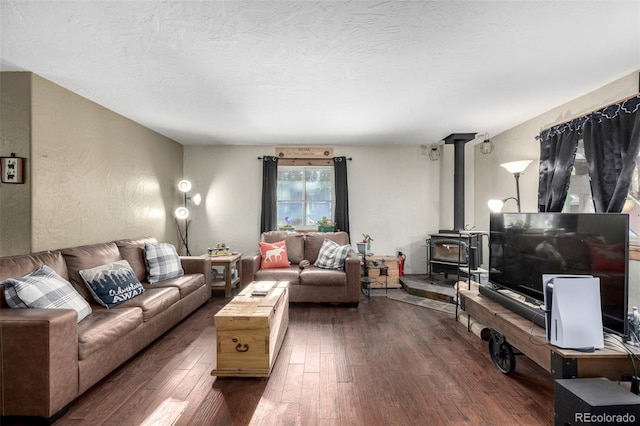 living room with dark hardwood / wood-style floors, a wood stove, and a textured ceiling