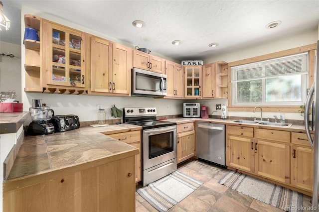 kitchen featuring appliances with stainless steel finishes, sink, and light brown cabinets