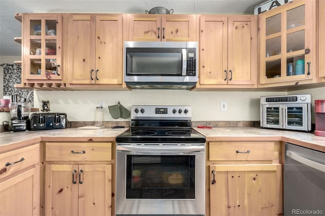 kitchen with light brown cabinets and appliances with stainless steel finishes