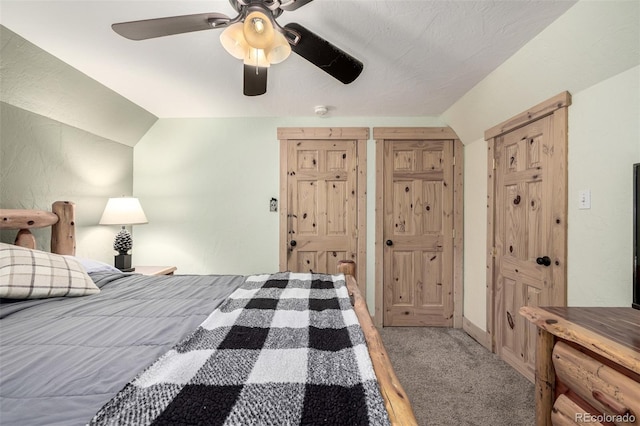 bedroom with ceiling fan, vaulted ceiling, and carpet flooring