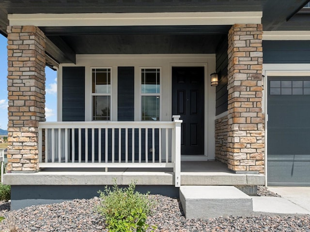 17843 W 93rd Pl, Arvada, CO 80007 - entrance to property featuring a porch, an attached garage, and stone siding