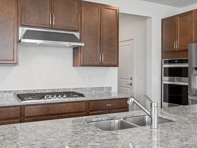 17843 W 93rd Pl, Arvada, CO 80007 - kitchen with exhaust hood, appliances with stainless steel finishes, and light stone countertops