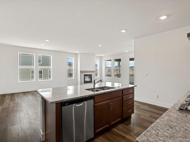 17843 W 93rd Pl, Arvada, CO 80007 - kitchen with dishwasher, open floor plan, dark wood-style flooring, light stone counters, and a glass covered fireplace