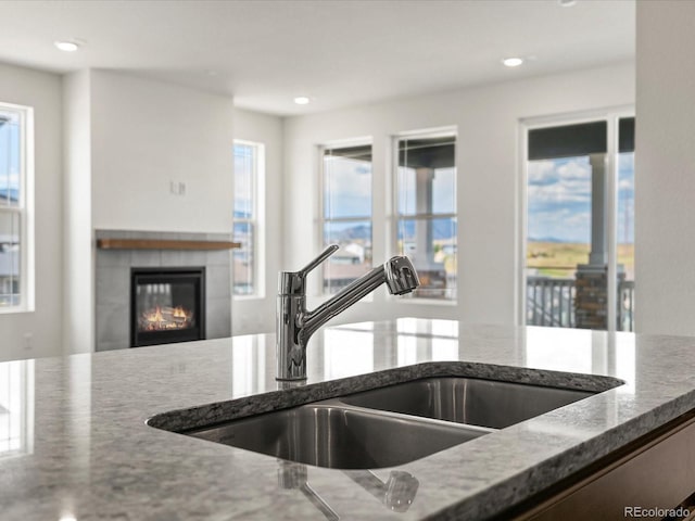 17843 W 93rd Pl, Arvada, CO 80007 - kitchen featuring stone counters, a fireplace, and recessed lighting