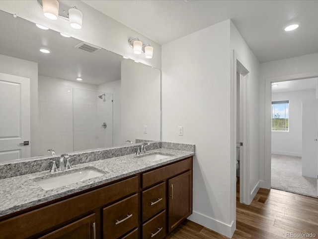 17843 W 93rd Pl, Arvada, CO 80007 - bathroom with wood finished floors, double vanity, tiled shower, and recessed lighting