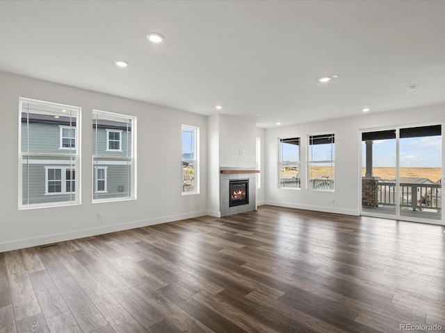 17843 W 93rd Pl, Arvada, CO 80007 - unfurnished living room with dark wood-type flooring, a tiled fireplace, and recessed lighting