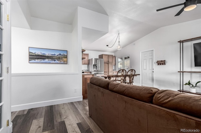 living room featuring lofted ceiling, ceiling fan, and wood-type flooring