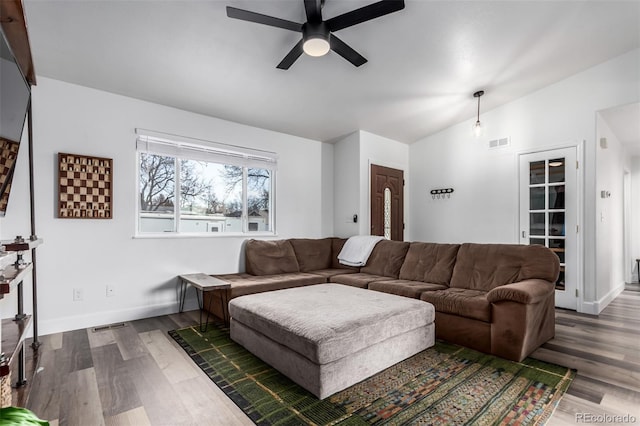 living room featuring ceiling fan, dark hardwood / wood-style floors, and vaulted ceiling