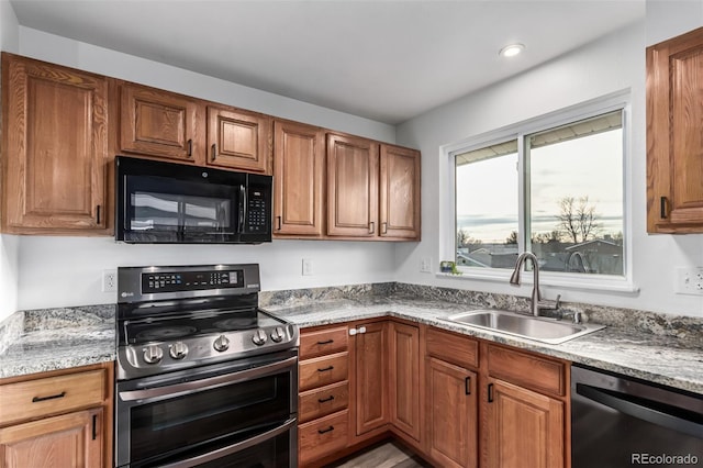 kitchen featuring sink, light stone countertops, and stainless steel appliances